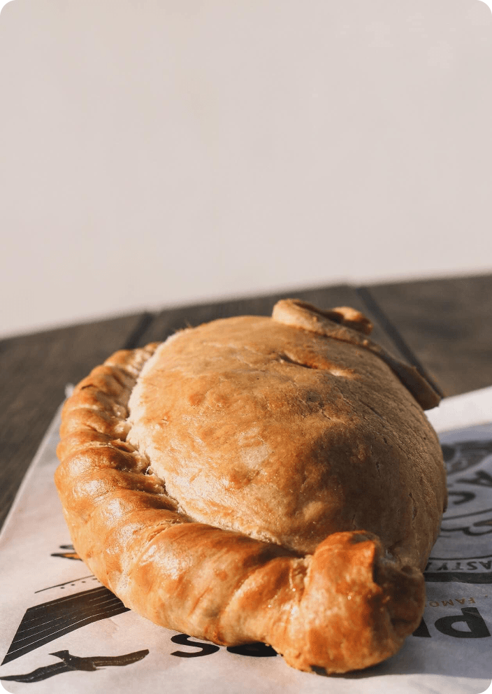 Close-up of a single Philps pasty resting on Philps-branded paper