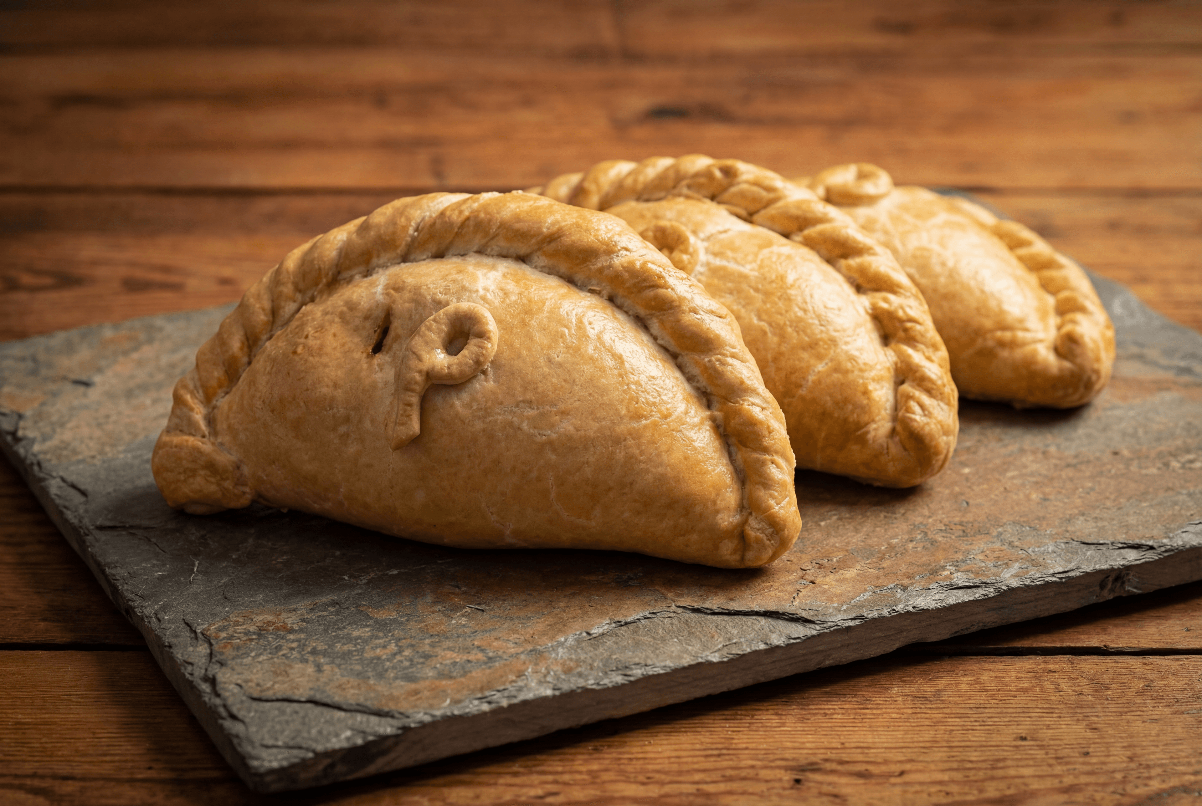 Three Philps standard Cornish pasties on a slate board